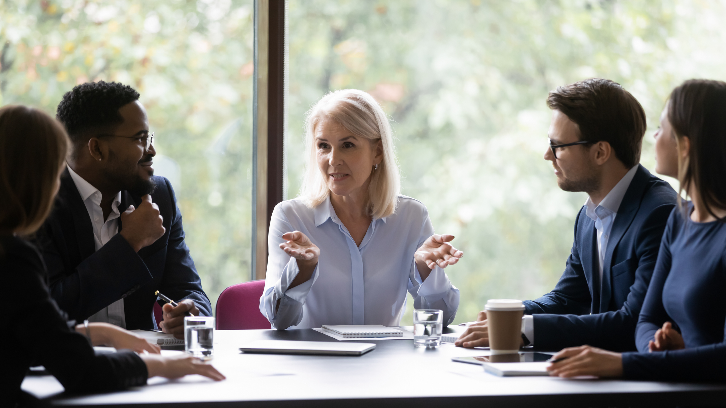 Mature leader boss give helpful information to young diverse professionals Mature leader boss give helpful information to young diverse professionals